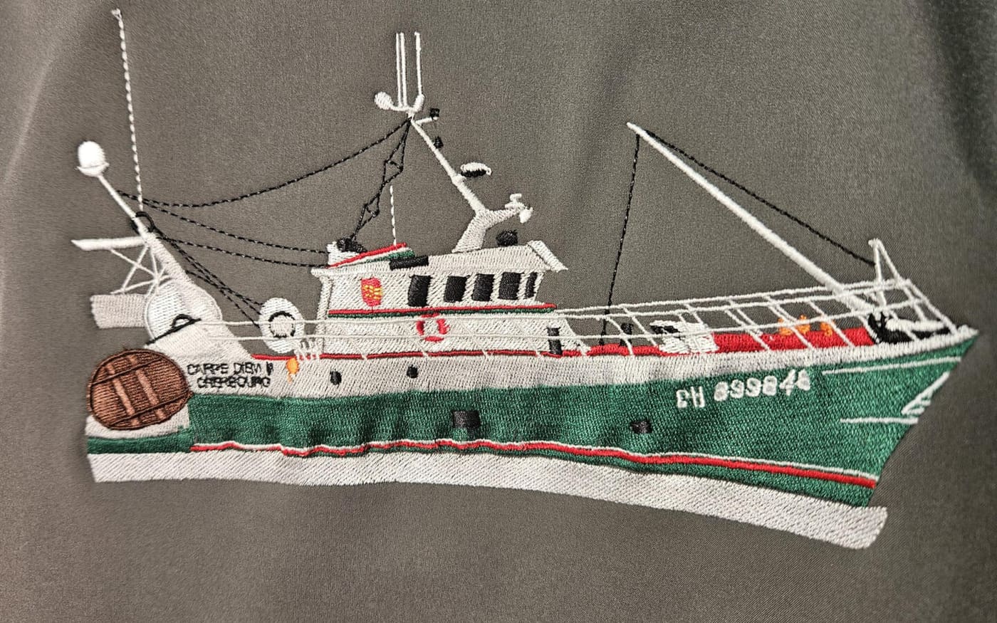 Broderie complexe d'un chalutier de pêche brodé fil à fil — coque, gréement, cordages et lettrage du nom du bateau