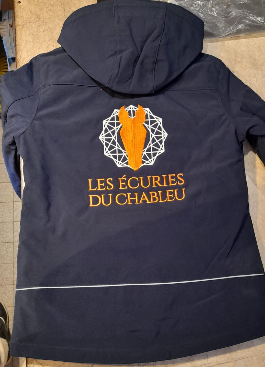 Logo d'entreprise brodé avec dégradé de couleurs sur veste softshell